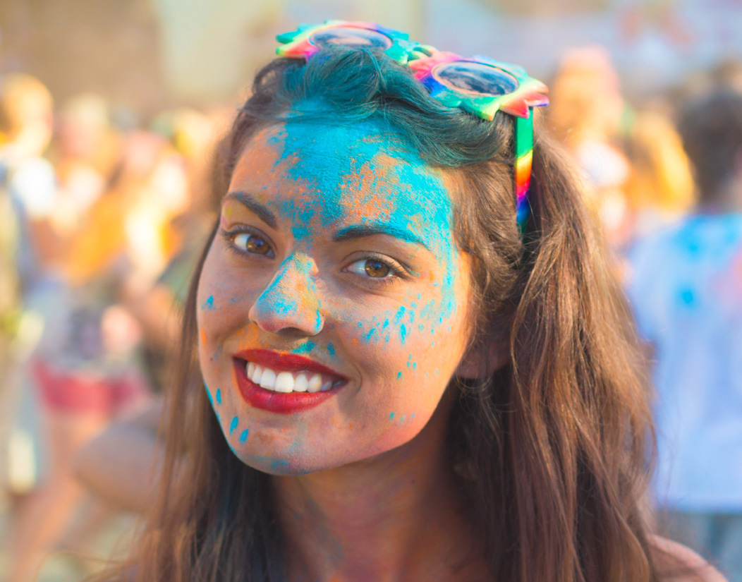 Portrait of happy young brunette girl on holi color festival